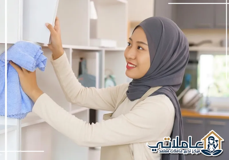 خادمة منزلية في عجمان تنظف رفوف المطبخ ضمن خدمات مكتب خدم عاملاتي