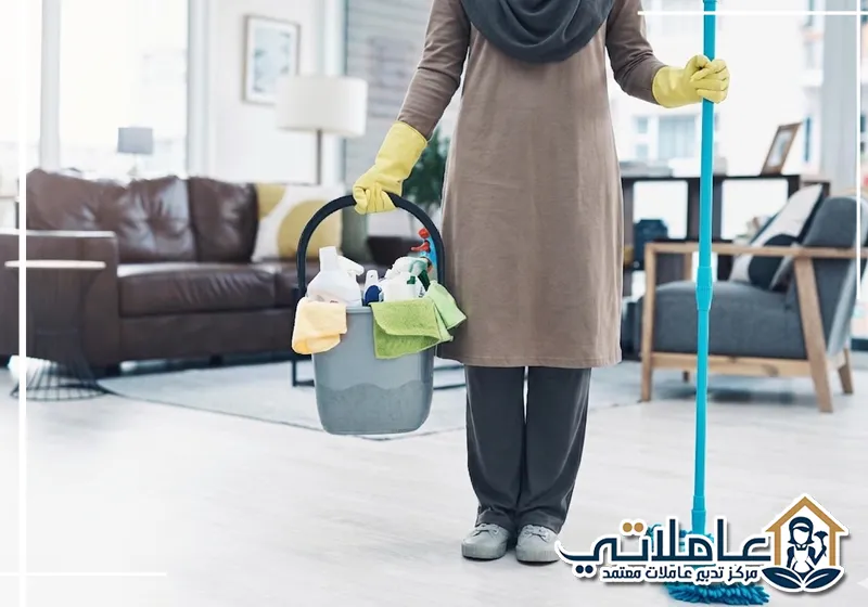 عاملة منزلية من عاملاتي تحمل أدوات التنظيف داخل منزل عصري، تعكس خدمات مكتب خدم في دبي باحترافية.