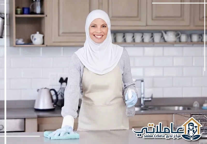 عاملة منزلية من عاملاتي تقوم بتنظيف المطبخ داخل منزل عصري.