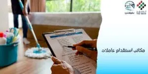 يد تملأ استمارة استقدام مربيات أطفال في الإمارات، وخلفها عاملة تنظف الأرضية بجوار أدوات التنظيف وشعار المكتب.