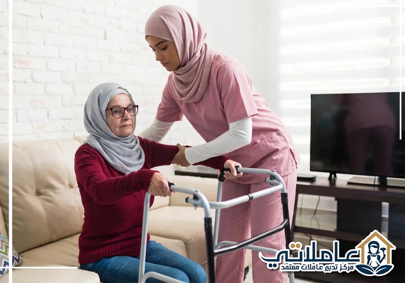 مقدمة رعاية تساعد سيدة مسنة على استخدام المشاية بأمان داخل المنزل.